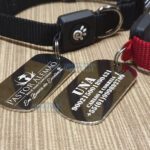 Duas medalhas de identificação de cão Mania de Metal com coleiras, uma preta e outra vermelha.