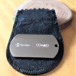 Dog Tag Grossa em Aço Inox 316L Stoller COAMO, placa plaqueta para presente em bolsa preta.