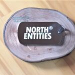 Dog Tag Grossa em Aço Inox 316L "NORTH ENTITIES" sobre madeira rústica. Plaqueta para presente.
