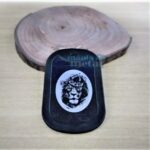 Dog Tag Fina preta com leão coroado gravado em branco.