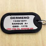 Dog tag Color prata com informações pessoais gravadas em preto, incluindo nome e tipo sanguíneo.