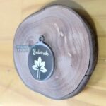 Placa Pingente Redondo em Aço Inox 316L Grosso com Gravação em base de madeira rústica.