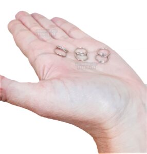 Elo terminal redondo 12mm em aço niquelado 12mm x 10mm x 1mm na palma da mão.